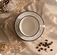 White and brown speckled ceramic tea cup